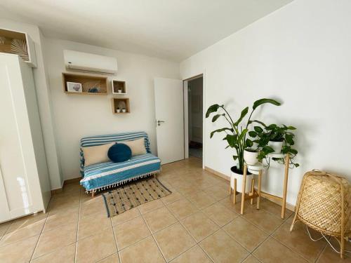 uma sala de estar com um sofá azul e uma planta em Casa da Boa Gente em Cabanas de Tavira