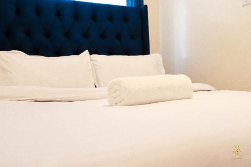 a white bed with a white pillow on it at Sweet Homes Ngong Road in Nairobi