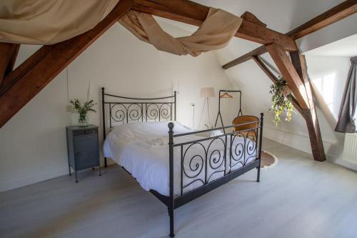 a bedroom with a black bed in a attic at De Hilde in Zutphen