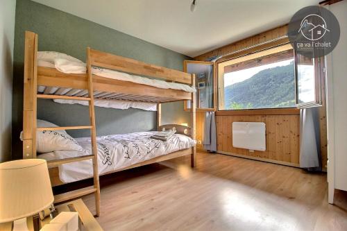 a bedroom with two bunk beds and a window at Chalet Arwi in Ovronnaz