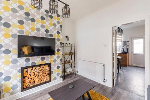 een woonkamer met een open haard en een televisie bij Charming Terraced House in Central Hoylake in Hoylake