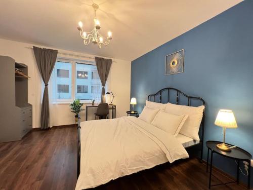 a bedroom with a bed with blue walls and a chandelier at Erkel Luxury Home in Budapest