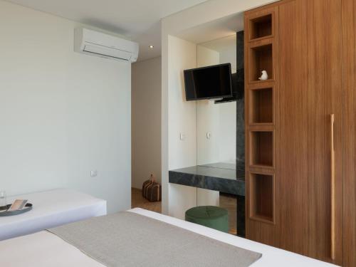 a bedroom with a bed and a cabinet with a television at Amphi Exclusive Residence in Somatás