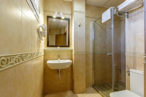 ein Bad mit einem Waschbecken und einer Dusche in der Unterkunft H-A Hotel Trebol in Málaga