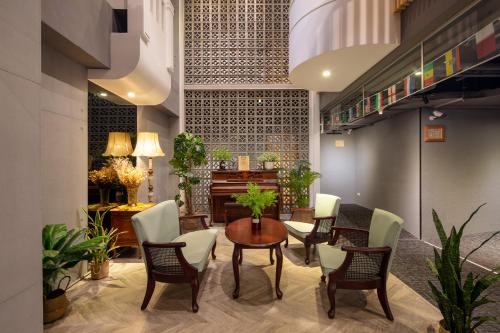 a room with a table and chairs and a piano at Cho Hotel 3 in Taipei