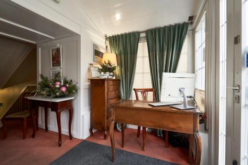 an office with a desk and a computer in a room at American House Hennela in Warsaw