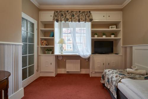 a bedroom with a window and a bed and a television at American House Hennela in Warsaw