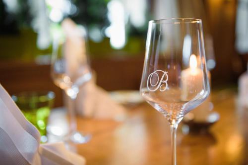 a wine glass sitting on a table with a candle at Hotel Gasthof Brandstätter in Salzburg