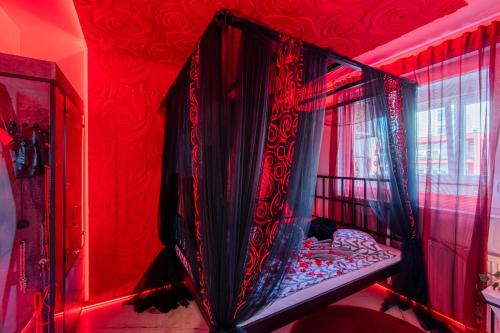 ein rotes Zimmer mit einem Bett mit Vorhängen und einem Fenster in der Unterkunft Jacuzzi - Love - BDSM - Extra Luxury - EV chargger - Valentine's Day - Red Room - Flexible SelfCheckIns 28 in Zagreb