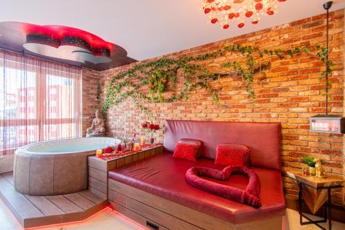 La salle de bains est pourvue d'une baignoire et d'un banc rouge. dans l'établissement Jacuzzi - Love - BDSM - Extra Luxury - EV chargger - Valentine's Day - Red Room - Flexible SelfCheckIns 28, à Zagreb