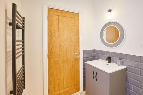 a bathroom with a sink and a wooden door at Apt 1 - Queens Court in Scarborough