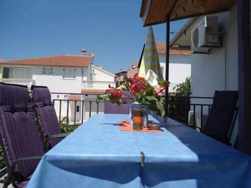 una mesa con un mantel azul y flores en el balcón en Apartments Villa Tanja, en Vodice
