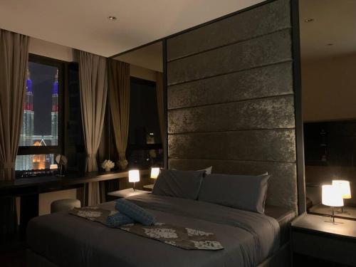 um quarto com uma cama grande e uma grande cabeceira. em Apartment in Bukit Bintang with a clear KLCC view em Kuala Lumpur