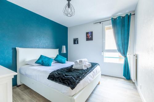 a bedroom with a white bed with blue walls at L'adorable Confort & Central in Clermont-Ferrand