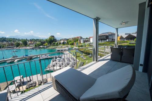 a balcony with a couch and a view of a marina at Boutiquehotel Wörthersee - Serviced Apartments in Velden am Wörthersee