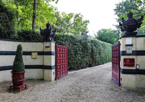 two gates to a garden with a tree in the middle at The Iflissen Nest - Luxury Appartment in Lamorlaye