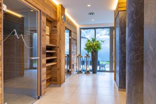 un corridoio con pareti in legno e una porta in vetro con una pianta di Mountain Hotel Luis a Kaprun