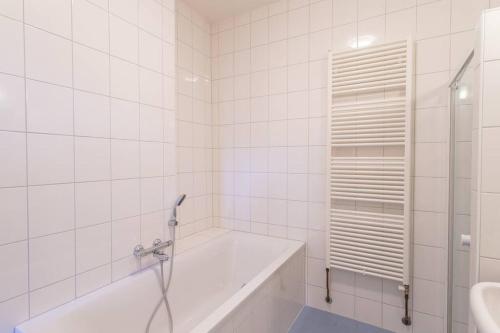 Baño blanco con bañera y lavamanos en De Dekenije en Zutphen