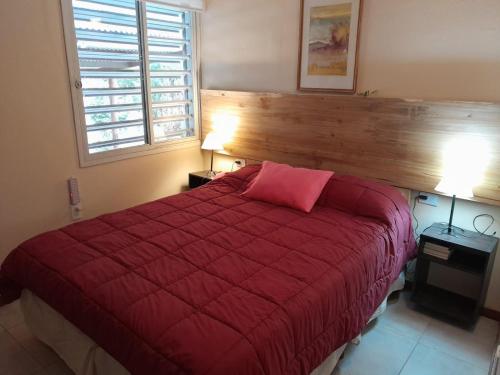 a bedroom with a red bed with a red blanket at AMORADA in Potrerillos