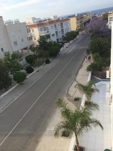 an empty city street with palm trees and buildings at Aphentrika Apartments in Protaras