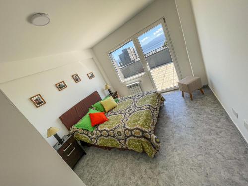 1 dormitorio con cama y ventana grande en Ganesha en San Carlos de Bariloche