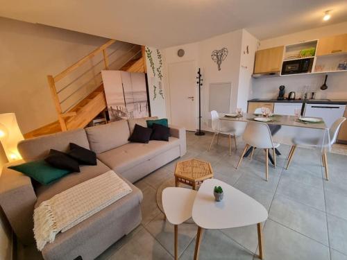 un salon avec un canapé et une table dans l'établissement La cabane de Mimimael Duplex 4 pers proche océan, à Mimizan