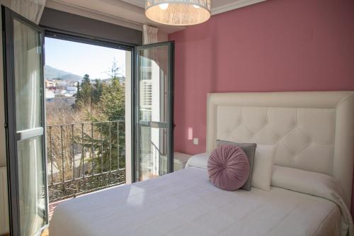 a bedroom with a white bed and a large window at AP Plaza la Hispanidad in Cuenca