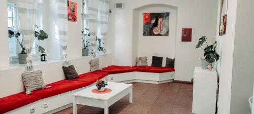 a living room with a red couch and a table at Safestay Prague Charles Bridge in Prague