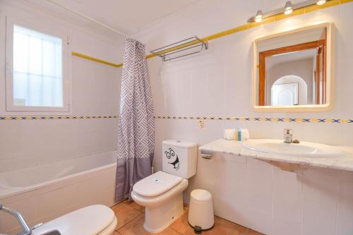 a white bathroom with a toilet and a sink at Monte Amarillo in Jávea