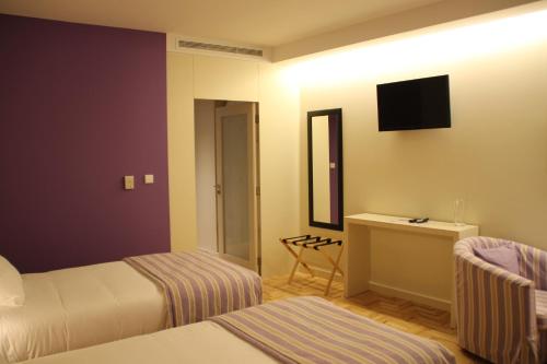 a hotel room with two beds and a television at Hotel Rural Misarela in Geres