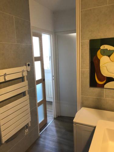 un baño con lavabo y una pintura en la pared en Champoiseau, en Tours