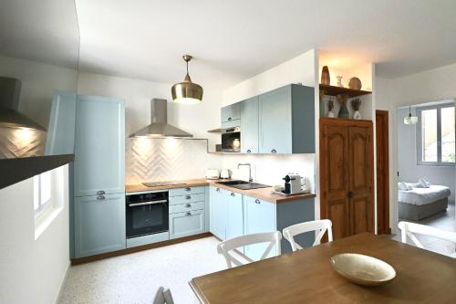 une cuisine avec des placards bleus et une table en bois dans l'établissement FERSEN Bright apartment renovated for 5 people in center of Old Antibes, à Antibes