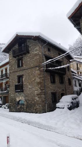 a brick building with a balcony in the snow at Argonz Etxea in Urzainqui