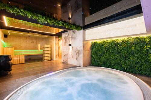 a lobby with a pool and a green wall at Tatry Residence SPA in Kościelisko