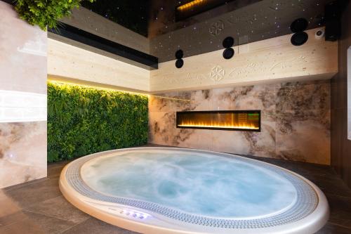 a jacuzzi tub in a room with a fireplace at Tatry Residence SPA in Kościelisko