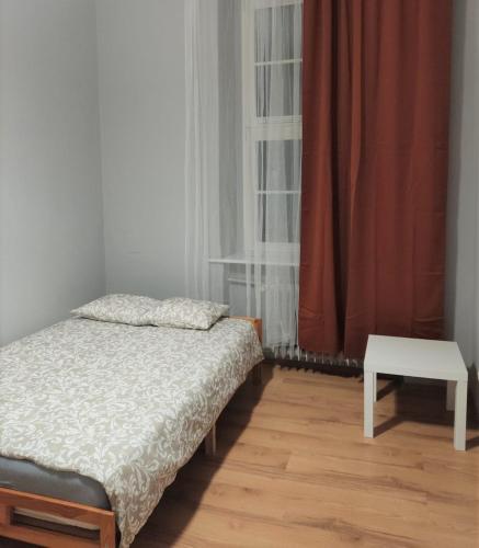 a small bedroom with a bed and a table at Rynek 7 in Poznań