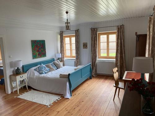 a bedroom with a bed with a blue headboard at Temelhof - Landhaus mit Sauna und Kamin in Sittersdorf