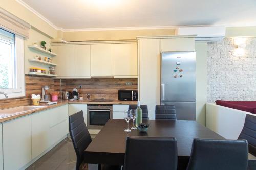 a kitchen with a dining table and a refrigerator at Luxury Memories Villa in Nikiti