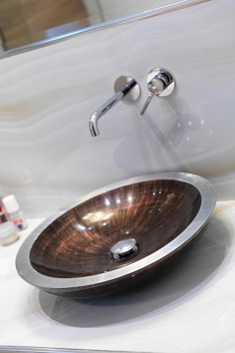 a bathroom sink with a wooden bowl on it at Luxury Memories Villa in Nikiti
