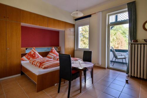 Schlafzimmer mit einem Bett, einem Tisch und einem Fenster in der Unterkunft Haus Erika in Bad Sooden-Allendorf