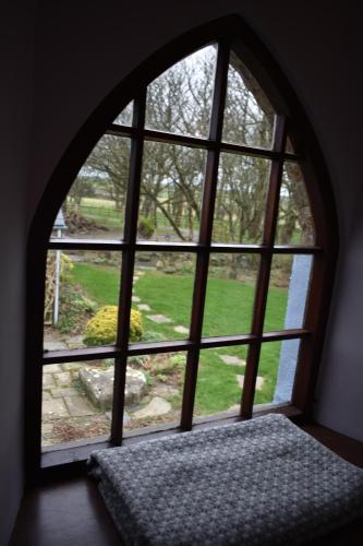 a room with a window looking out at a garden at Crug Glas Country House in St. Davids