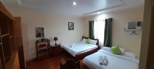 a hotel room with two beds and a window at CORALYN'S PLACE Family of 5 in Boracay