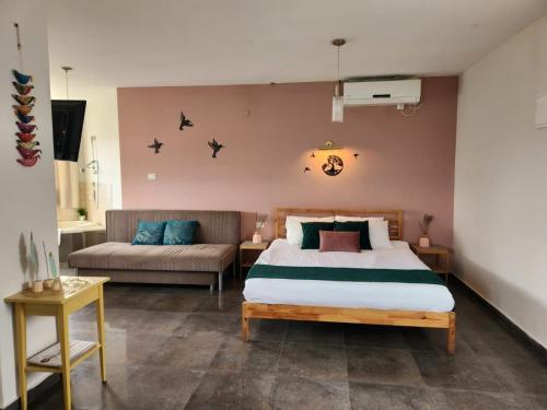 um quarto com uma cama e um sofá em Zug Yonim em Livnim
