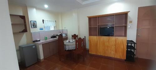 a room with a kitchen with a television and a counter at CORALYN'S PLACE Family of 5 in Boracay