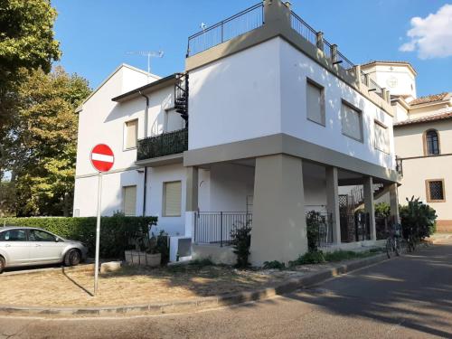 un edificio blanco con un letrero de la calle delante de él en vada vacanze, en Vada