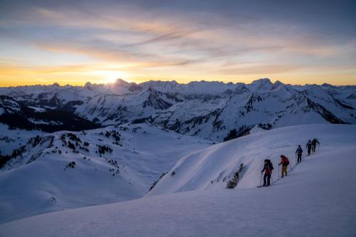 a group of people hiking up a snow covered mountain at Gabriela Apartments in Mellau