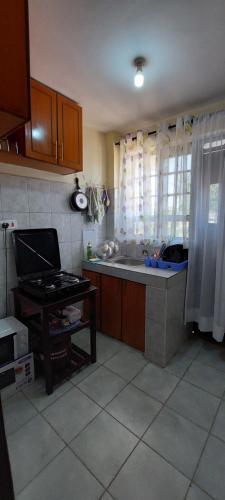 a kitchen with a counter and a sink and a table at The Crystal Skep - One-bedroomed apartment in Kakamega