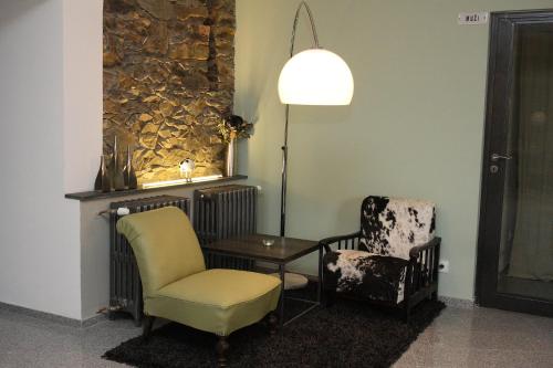 a living room with two chairs and a table and a lamp at Alt pension in Prague