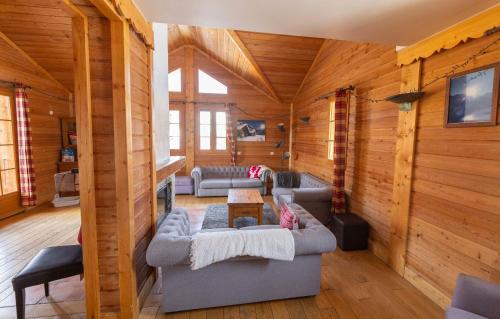 a living room with wood paneled walls and couches at Odalys Chalet Diane in L'Alpe-d'Huez