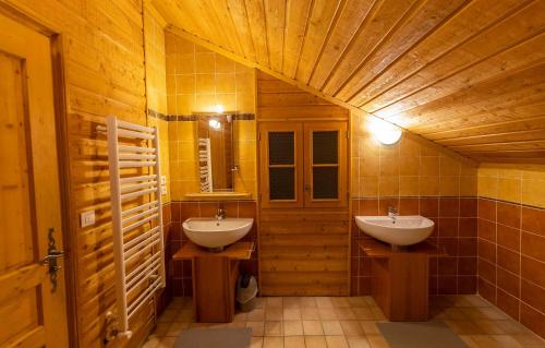 a bathroom with two sinks and a wooden ceiling at Odalys Chalet Diane in L'Alpe-d'Huez